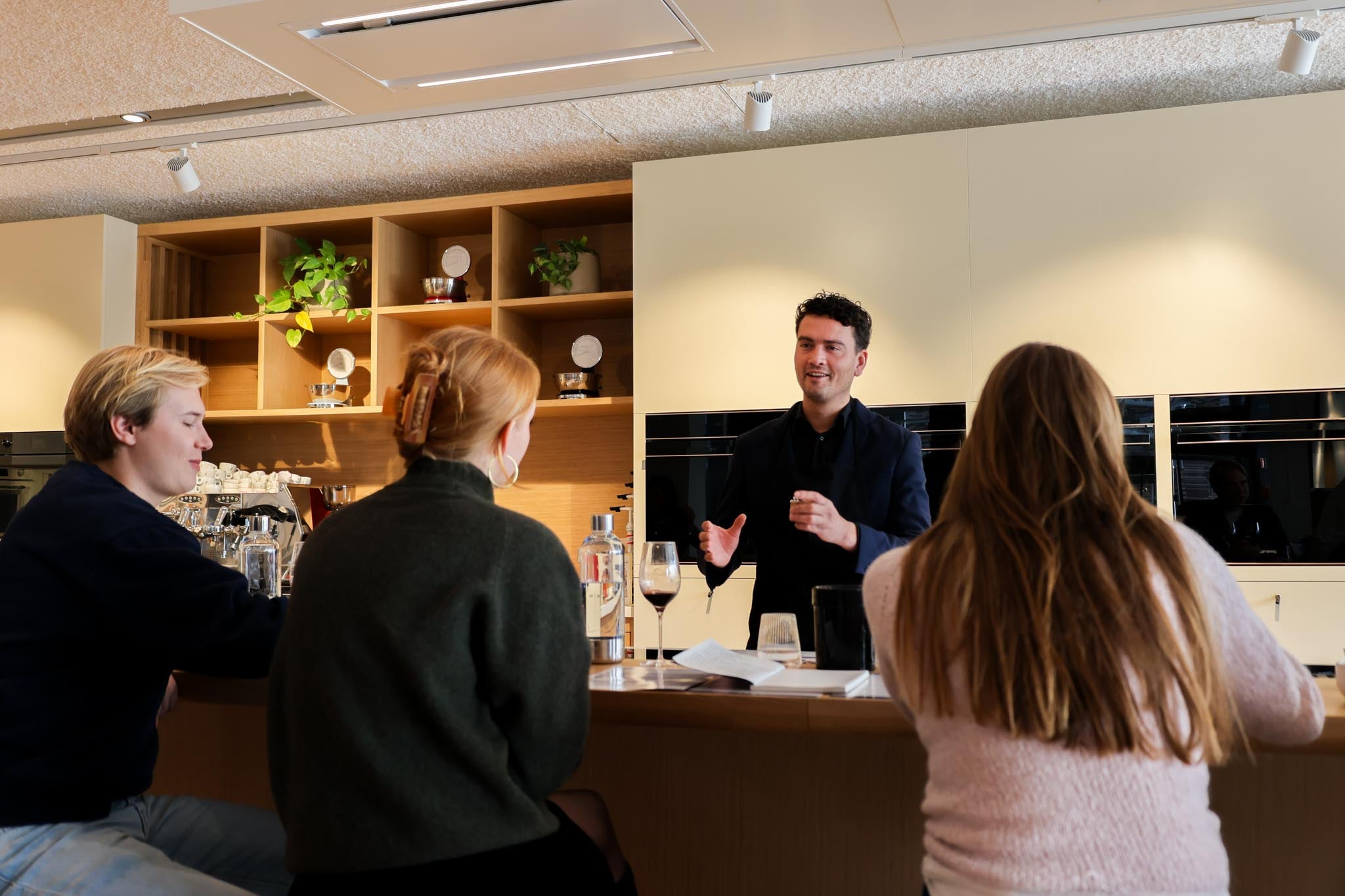 A sommelier hosting a wine tasting for a corporate group in the SMEG showroom