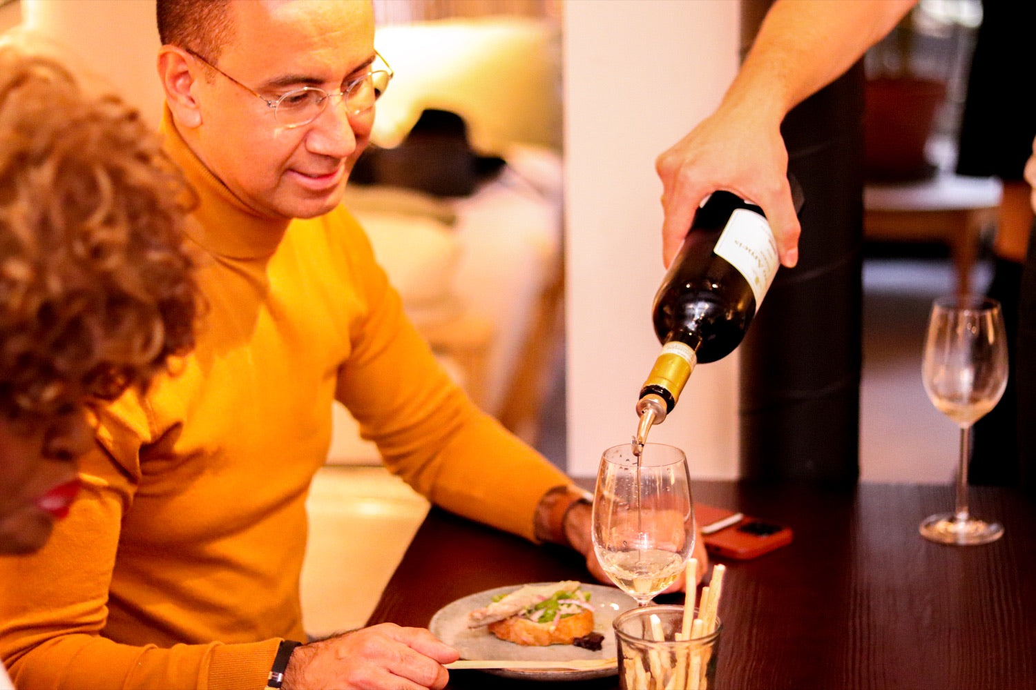Wine being poured alongside a food pairing
