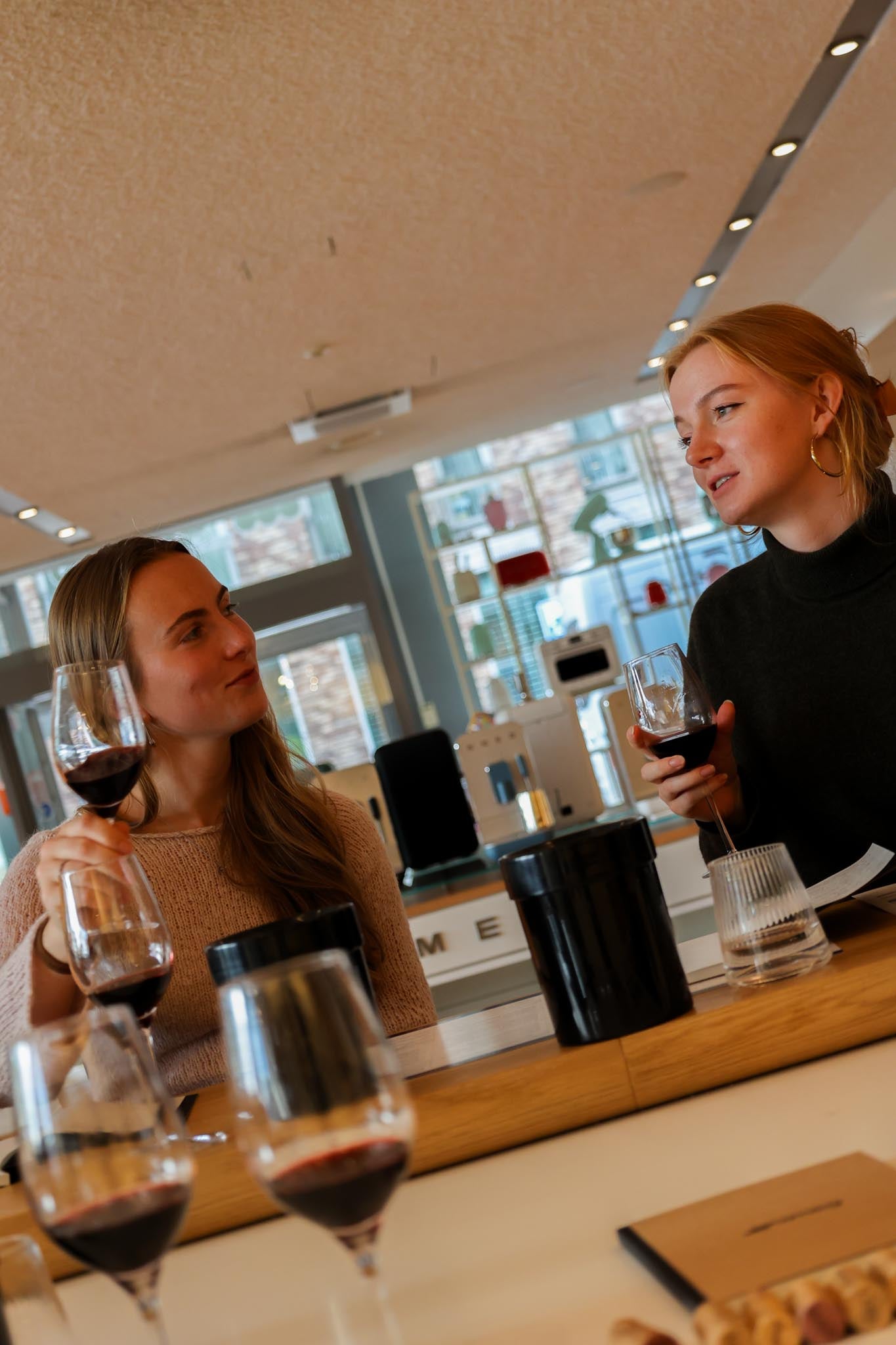 Two guests talking over a glass of red wine at a corporate event