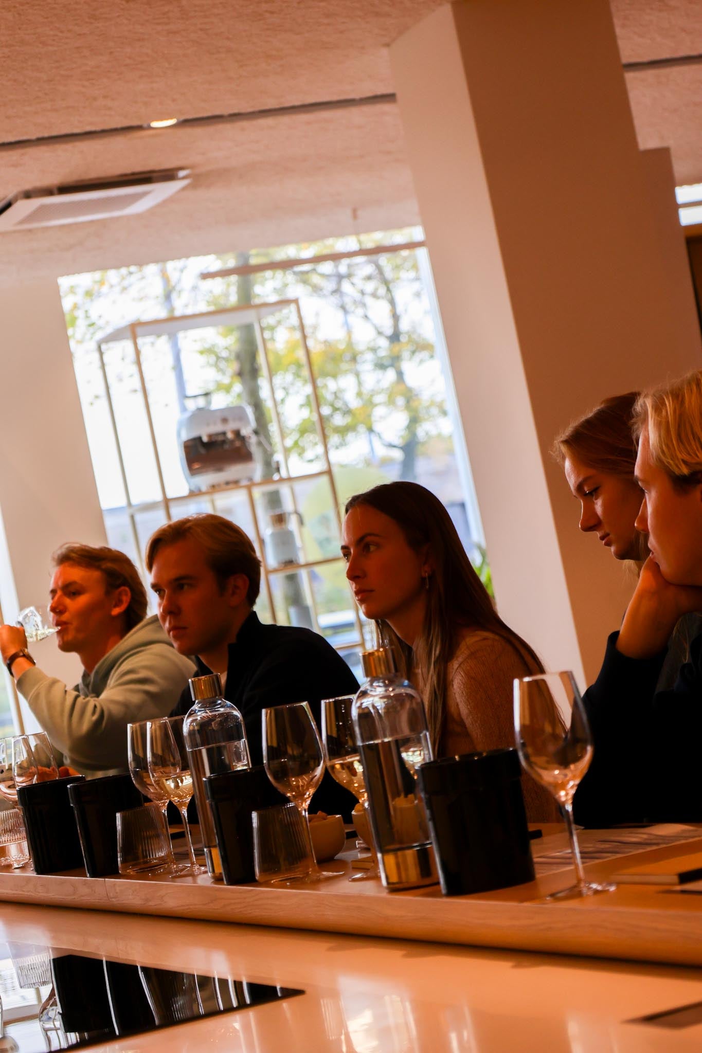 A team listening to the sommelier during a daytime corporate tasting